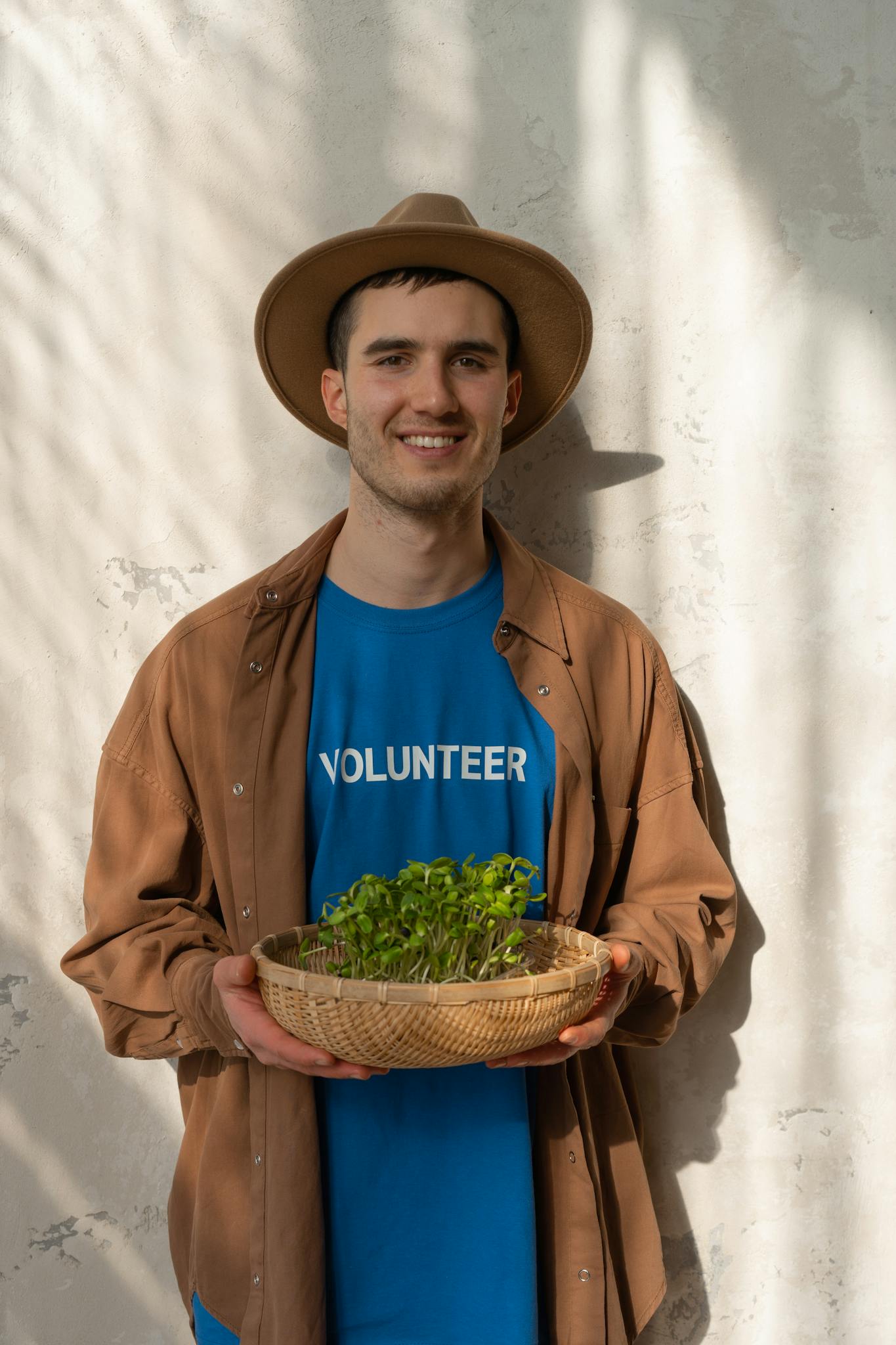 Young volunteer holding a basket of seedlings, promoting growth and sustainability.